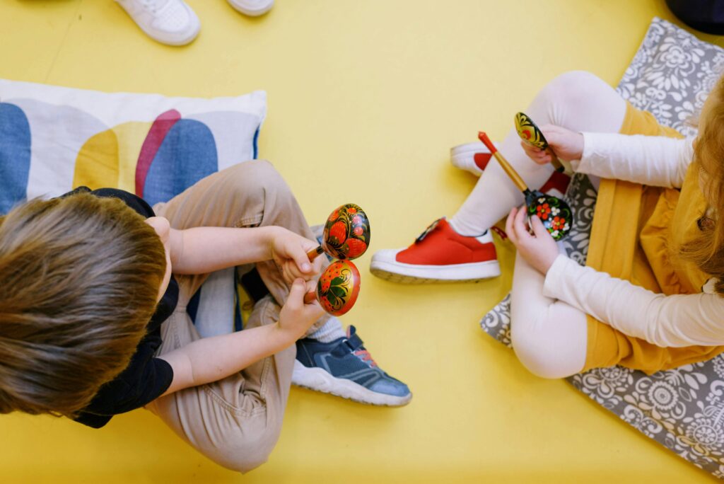 Joyful children playing maracas in a colorful preschool setting.